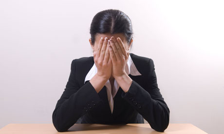 A businesswoman with her head in her hands
